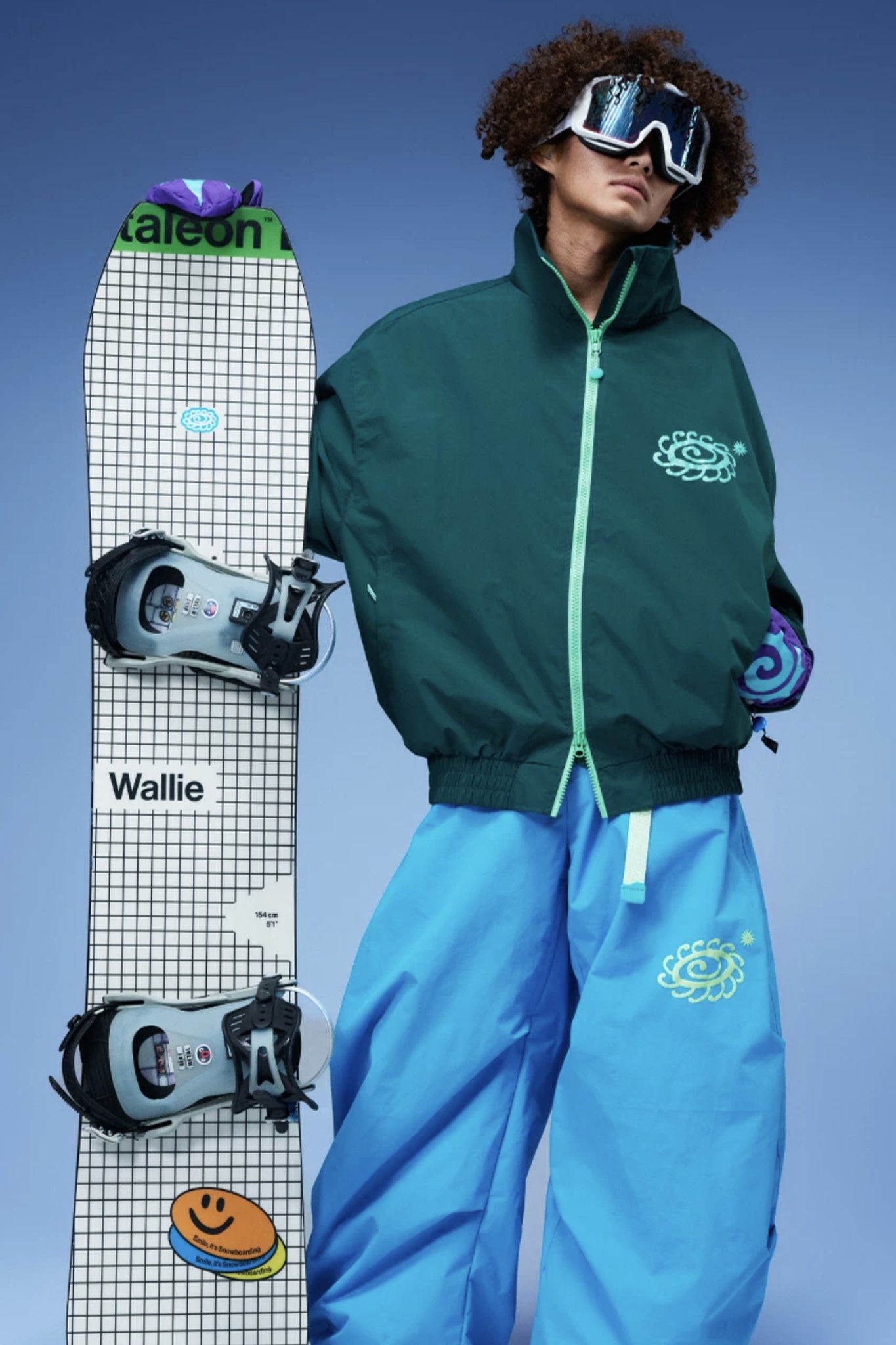 OddyEddy Ash Green ski jacket styled with blue snowboard pants and snowboard