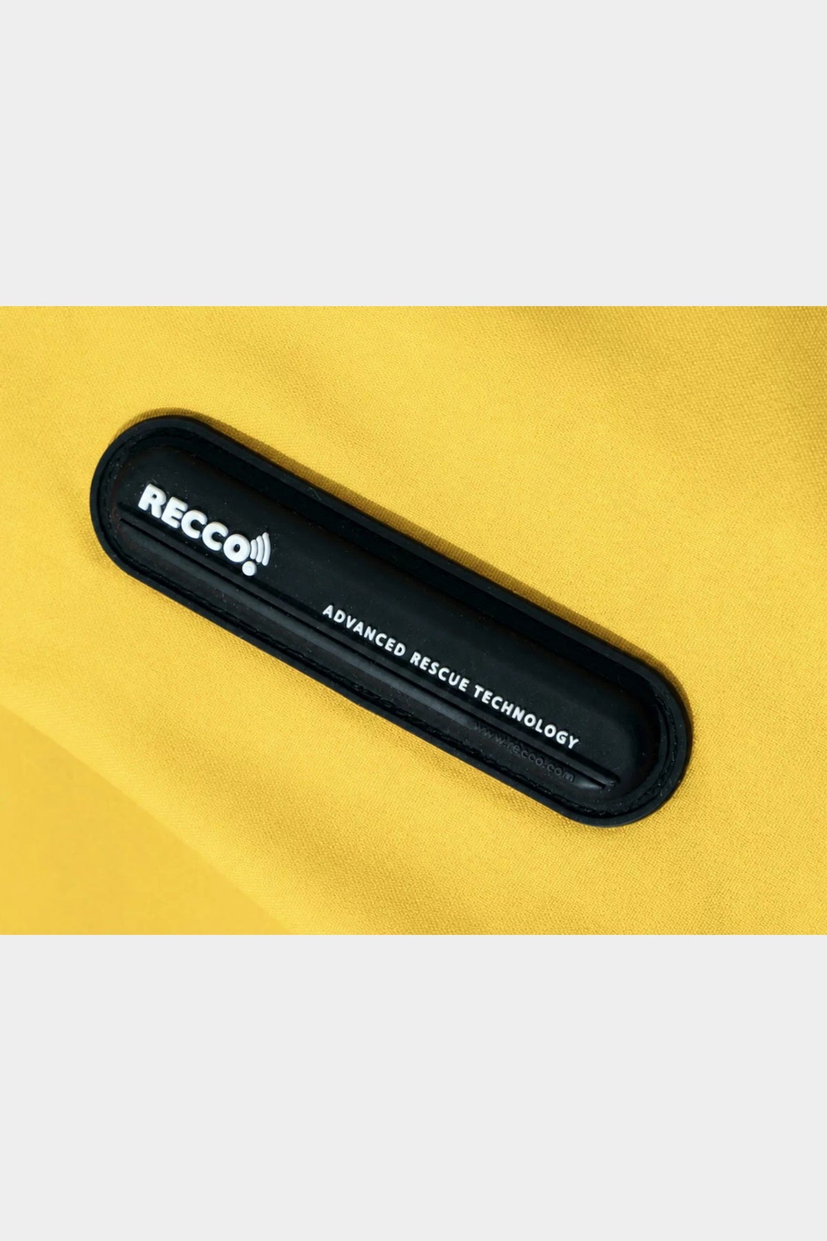 Yellow Winter Ticket jacket fabric detail with RECCO reflector badge